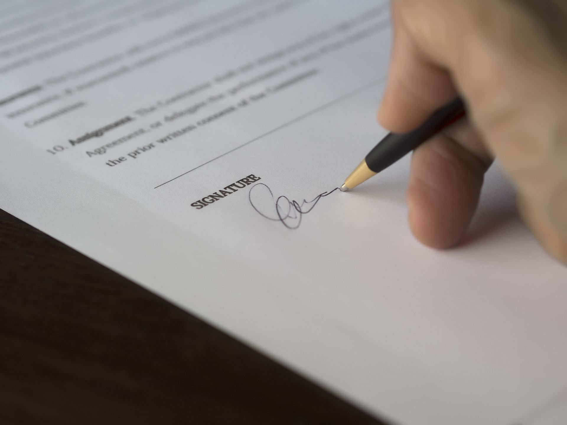 Closeup of someone signing a contract agreement.